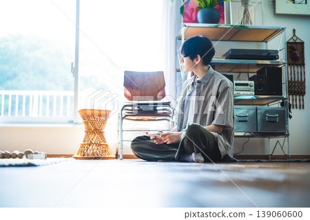 A young man sitting by the window A young man sitting by the window 139060600