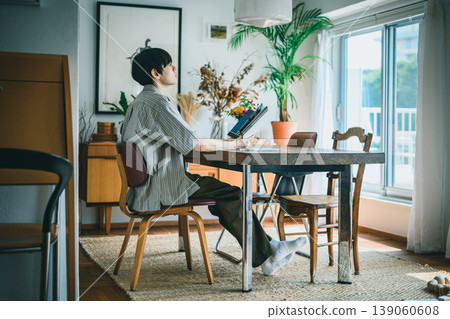 A young man looking at a tablet indoors. 139060608