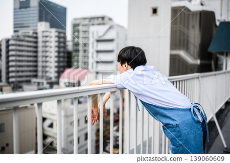 A man standing on a rooftop in the city A man standing on a rooftop in the city 139060609