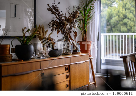 Dried flowers and houseplants on a wooden cabinet Dried flowers and houseplants on a wooden cabinet 139060611