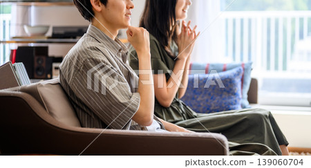 Close-up of a man and a woman sitting side-by-side on a sofa. Close-up of a man and a woman sitting side-by-side on a sofa. 139060704