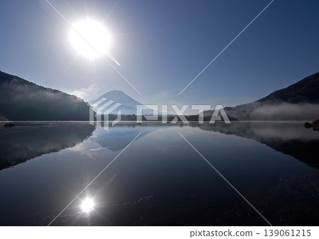 秋日清晨,精進湖籠罩在薄霧之中。富士山的輪廓倒映在湖面上,陽光下,富士山的倒影顯得格外美麗。 秋日清晨,精進湖籠罩在薄霧之中。富士山的輪廓倒映在湖面上,陽光下,富士山的倒影顯得格外美麗。 139061215