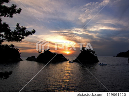西伊豆的日落景色美極了。島嶼的輪廓與橙色的夕陽形成鮮明對比,令人印象深刻。 西伊豆的日落景色美極了。島嶼的輪廓與橙色的夕陽形成鮮明對比,令人印象深刻。 139061220