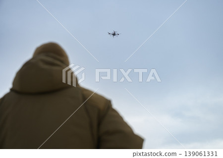 Soldier watching drone flying in cloudy sky Soldier watching drone flying in cloudy sky 139061331