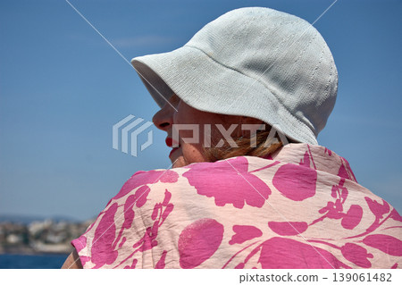 Older woman wearing a hat enjoys the boat return from the Calanques under the blue Marseille sky in summer 139061482