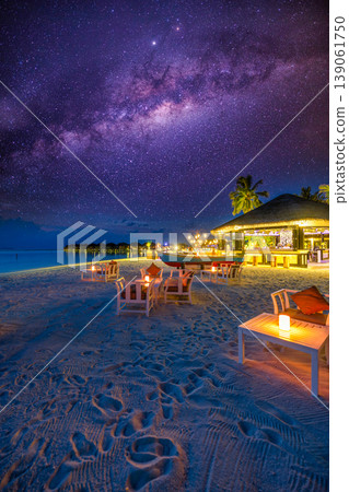 Night beach bar milky way lights calm ocean view horizon amazing summer travel tourism background relax fun outdoors chairs tables stars paradise Night beach bar milky way lights calm ocean view horizon amazing summer travel tourism background relax fun outdoors chairs tables stars paradise 139061750