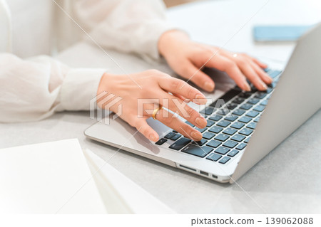 A woman's hands while using a laptop (typing, teleworking, side job, part-time work) A woman's hands while using a laptop (typing, teleworking, side job, part-time work) 139062088