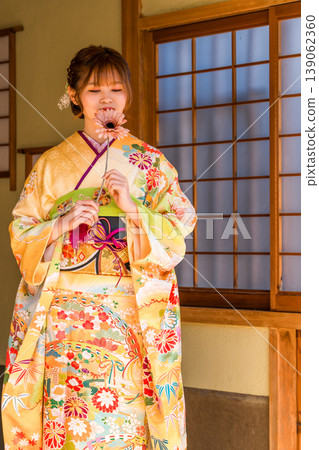 A young Japanese woman wearing a furisode kimono in a Japanese-style room (coming-of-age ceremony, graduation ceremony, wedding). A young Japanese woman wearing a furisode kimono in a Japanese-style room (coming-of-age ceremony, graduation ceremony, wedding). 139062360