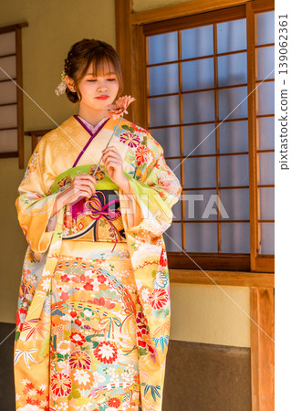 A young Japanese woman wearing a furisode kimono in a Japanese-style room (coming-of-age ceremony, graduation ceremony, wedding). A young Japanese woman wearing a furisode kimono in a Japanese-style room (coming-of-age ceremony, graduation ceremony, wedding). 139062361