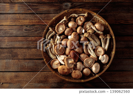 An assortment of mushrooms on a rustic wooden board. 139062560