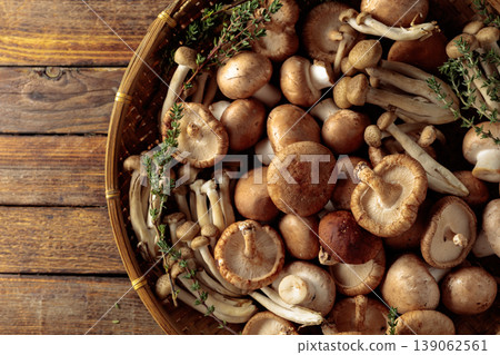 An assortment of mushrooms on a rustic wooden board with sprigs of thyme. An assortment of mushrooms on a rustic wooden board with sprigs of thyme. 139062561