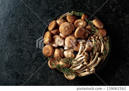 An assortment of mushrooms on a black table. 139062562
