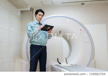 Engineers maintaining hospital CT scanners. Photo courtesy of Denpa Gakuen Educational Foundation, Tokyo Electronics College. 139062594