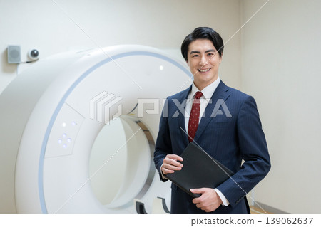 A businessman maintaining a hospital's CT scanner. Filming assistance provided by: Denpa Gakuen Educational Foundation, Tokyo Electronics College. A businessman maintaining a hospital's CT scanner. Filming assistance provided by: Denpa Gakuen Educational Foundation, Tokyo Electronics College. 139062637