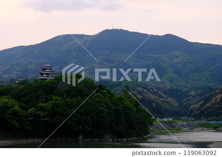 The sun sets over Ozu Castle, which stands on the banks of the Hijikawa River in Ozu City. The sun sets over Ozu Castle, which stands on the banks of the Hijikawa River in Ozu City. 139063092
