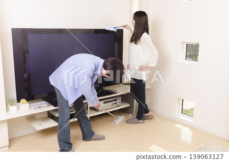 A young couple cleaning together A young couple cleaning together 139063127