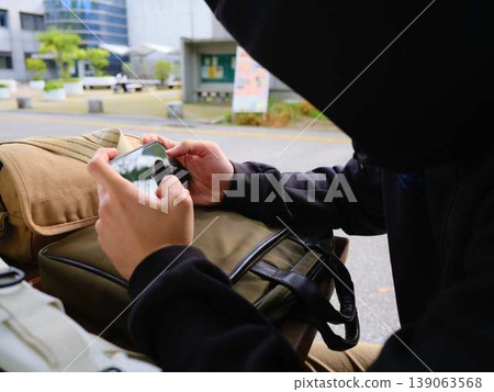 Hands of a man looking at a smartphone Hands of a man looking at a smartphone 139063568