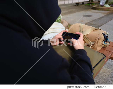 Hands of a man looking at a smartphone Hands of a man looking at a smartphone 139063602