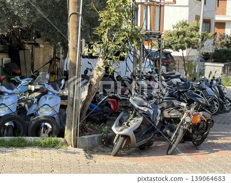 Abandoned scooters and motorbikes parked on street in urban environment daytime 139064683