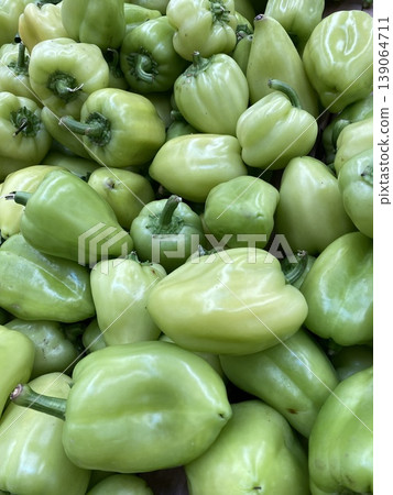 Green bell peppers piled up showcasing freshness and vibrant color suitable for background Green bell peppers piled up showcasing freshness and vibrant color suitable for background 139064711