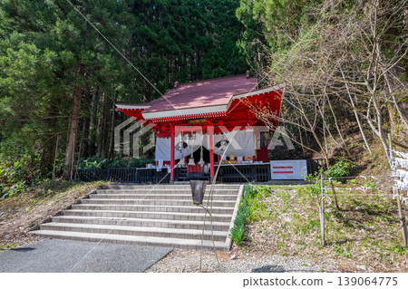 秋田縣田澤湖畔的御在石神社:一座鮮豔的朱紅色神社建築在鬱鬱蔥蔥的森林中格外醒目。 秋田縣田澤湖畔的御在石神社:一座鮮豔的朱紅色神社建築在鬱鬱蔥蔥的森林中格外醒目。 139064775
