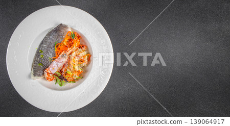Healthy seafood dish with fish fillet and fresh vegetable salad on plate top view copy space 139064917