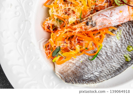 Grilled dorado fish fillet with fresh vegetable salad and grated cheese close up 139064918