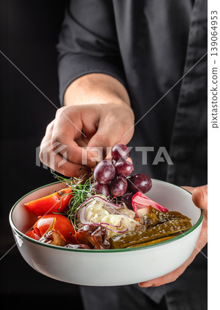 Hand holding bowl with pickled vegetables and grapes healthy food concept Hand holding bowl with pickled vegetables and grapes healthy food concept 139064953