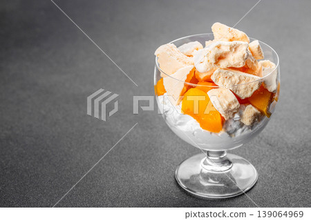 British dessert Eton mess with peach meringue and cream in glass copy space 139064969