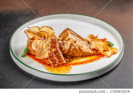 Honey cake dessert with dried apple chips and honeycomb on plate 139065024