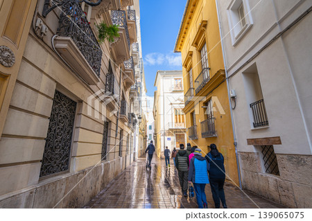 Tourists Walking Through a Narrow Street in Valencia Spain Tourists Walking Through a Narrow Street in Valencia Spain 139065075
