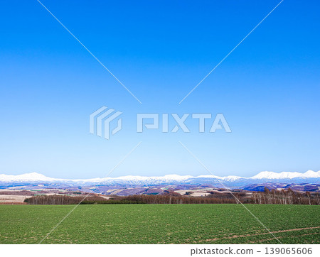 A spring landscape viewed from the hills of Biei, where mountains and a refreshing blue sky stretch out. A spring landscape viewed from the hills of Biei, where mountains and a refreshing blue sky stretch out. 139065606