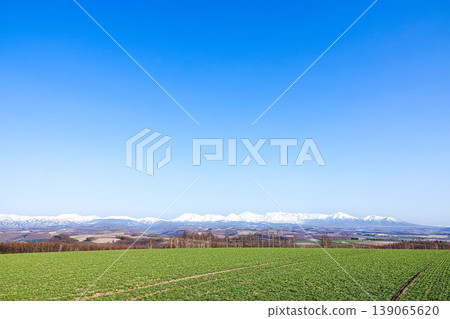 A spring landscape viewed from the hills of Biei, where mountains and a refreshing blue sky stretch out. A spring landscape viewed from the hills of Biei, where mountains and a refreshing blue sky stretch out. 139065620