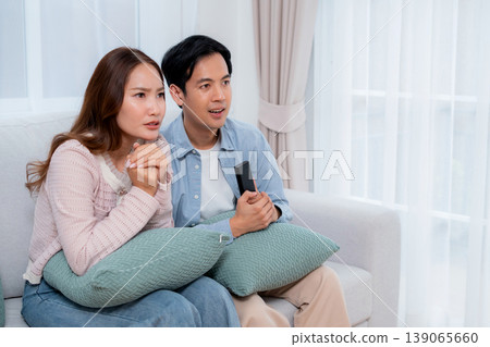 Young asian couple sitting on sofa in living room at home. Young asian couple sitting on sofa in living room at home. 139065660