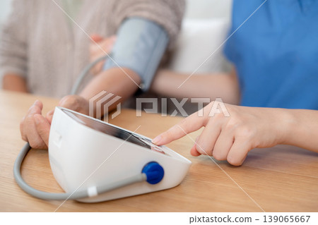Asian woman nurse measuring blood pressure senior patient. 139065667