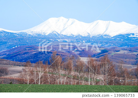 Snow-capped Optateshike mountain and a view from a hilltop in Biei, Hokkaido in spring. Snow-capped Optateshike mountain and a view from a hilltop in Biei, Hokkaido in spring. 139065733