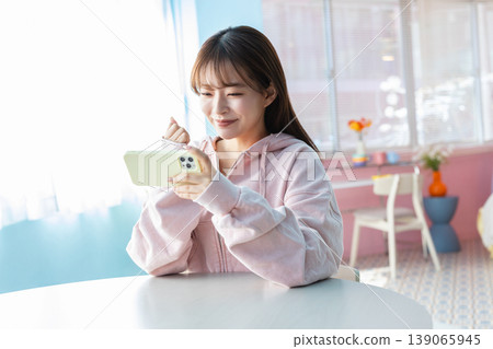 A woman watching a video on a smartphone 139065945