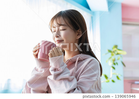 Young woman drinking a drink in the room 139065946