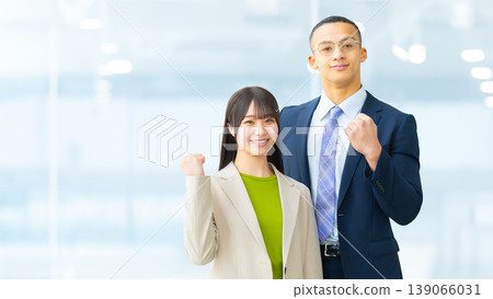 Two businessmen, a man and a woman, make a triumphant gesture. Two businessmen, a man and a woman, make a triumphant gesture. 139066031