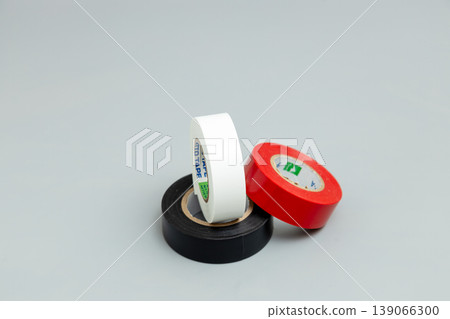 紅色、白色和黑色電工膠帶;灰色背景,留有文字空間。 紅色、白色和黑色電工膠帶;灰色背景,留有文字空間。 139066300