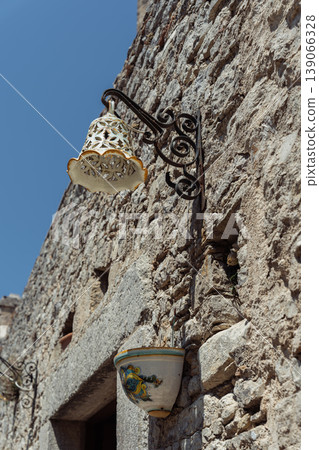 Ceramic shaded decorative streetlights and stone walls 139066328