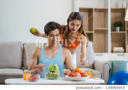 Fit couple enjoys healthy fruit breakfast after yoga training. fitness, nutrition, home lifestyle. Fit couple enjoys healthy fruit breakfast after yoga training. fitness, nutrition, home lifestyle. 139066950
