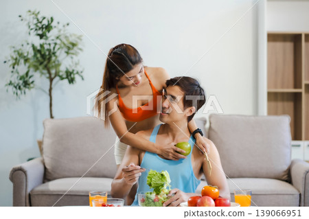 Fit couple enjoys healthy fruit breakfast after yoga training. fitness, nutrition, home lifestyle. Fit couple enjoys healthy fruit breakfast after yoga training. fitness, nutrition, home lifestyle. 139066951