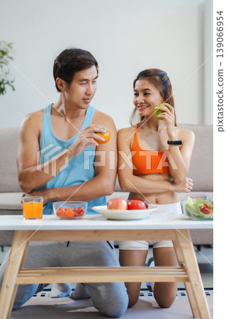 Fit couple enjoys healthy fruit breakfast after yoga training. fitness, nutrition, home lifestyle. Fit couple enjoys healthy fruit breakfast after yoga training. fitness, nutrition, home lifestyle. 139066954