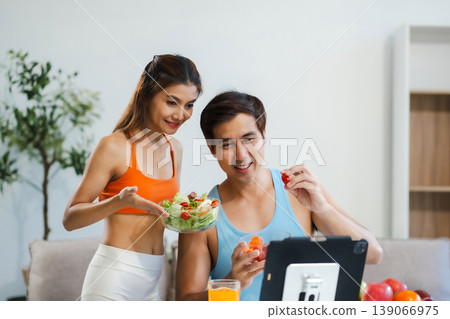 Fit couple enjoys healthy fruit breakfast after yoga training. fitness, nutrition, home lifestyle. Fit couple enjoys healthy fruit breakfast after yoga training. fitness, nutrition, home lifestyle. 139066975