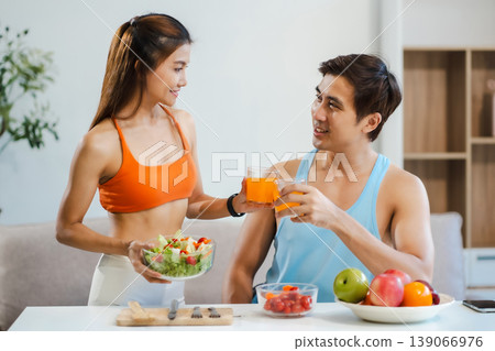 Fit couple enjoys healthy fruit breakfast after yoga training. fitness, nutrition, home lifestyle. Fit couple enjoys healthy fruit breakfast after yoga training. fitness, nutrition, home lifestyle. 139066976