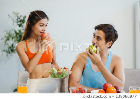 Fit couple enjoys healthy fruit breakfast after yoga training. fitness, nutrition, home lifestyle. Fit couple enjoys healthy fruit breakfast after yoga training. fitness, nutrition, home lifestyle. 139066977