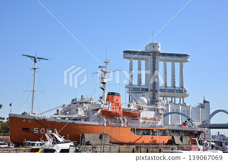 The side view of the Antarctic research vessel Fuji, which is docked in Nagoya Port, and the Nagoya Port Building. 139067069