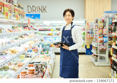 Supermarket employee with a tablet device Supermarket employee with a tablet device 139067171