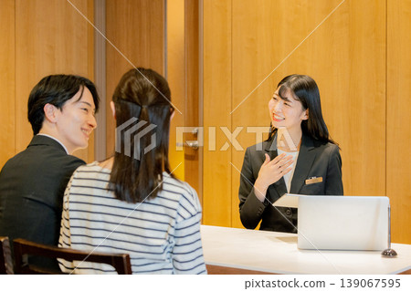 The woman giving the explanation at the reception desk The woman giving the explanation at the reception desk 139067595